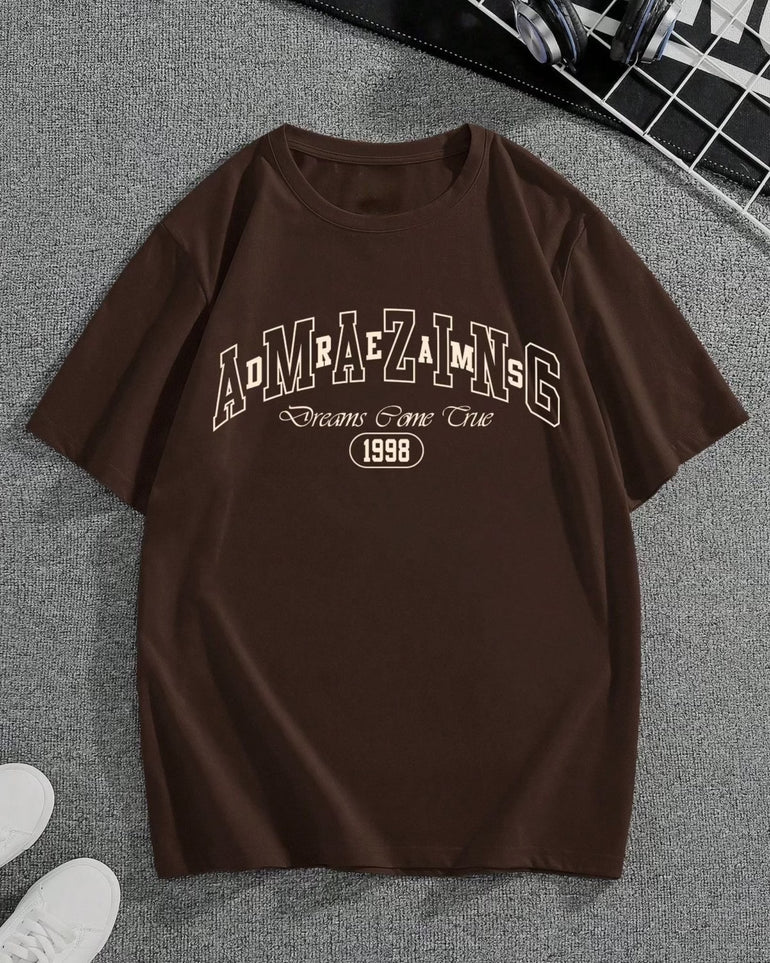 A casual, oversized brown t-shirt featuring a drop shoulder design, displayed in a relaxed fit. The t-shirt is made from soft, breathable cotton fabric, with slightly extended sleeves and a loose silhouette that emphasizes comfort and streetwear style. The rich brown color adds warmth and versatility, making it suitable for layering or standalone wear in everyday outfits.
