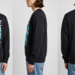 Front, side, and back view of a male model wearing a black Ganaplle sweatshirt featuring colorful abstract art and bold typography, paired with blue jeans.